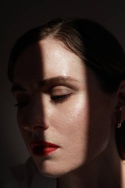 Kırmızı dudaklı çekici bir genç kadın. Güzel bir kadının dikey yakın çekimi..