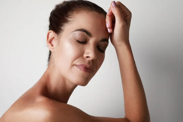 Portrait de belle femme âgée touchant sa peau parfaite isolée sur fond gris. Concept de processus de vieillissement. — Photo