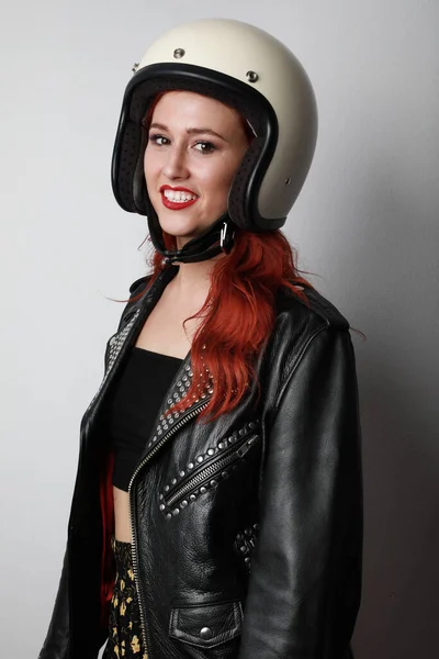 Vertical headshot de mulher bonita com roupa de motociclista, posando isolado sobre a parede branca. — Fotografia de Stock