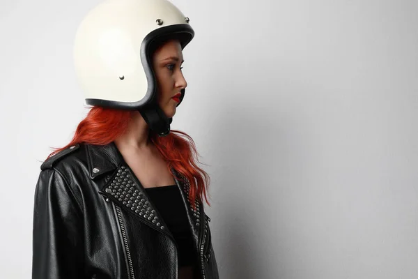 Retrato lateral de uma jovem com um capacete de motocicleta posando sobre fundo branco isolado. Espaço para texto. — Fotografia de Stock