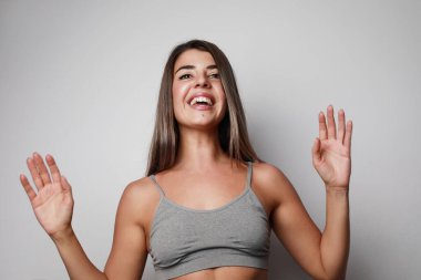 Mutlu genç kadın. Beyaz duvarın üzerinde izole edilmiş..