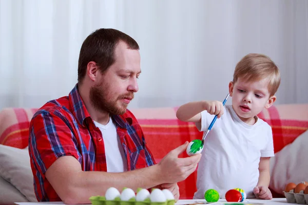 boy and dad paint eggs