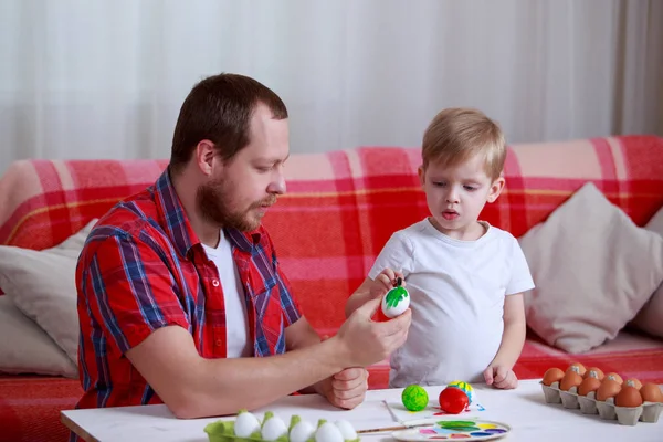 boy and dad paint eggs