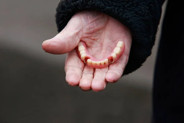 Denti falsi nelle vecchie mani — Foto Stock