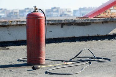 Çatıda ocağı olan kırmızı bir varil.