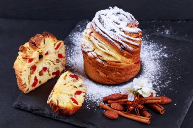 Gri arka planda kuru üzüm ve tarçın çubukları olan büyük bir Kraffin.