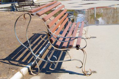 Şehirde Park, güneş tarafından aydınlatılmış kahverengi ahşap Bank