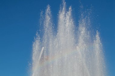Çeşme su jetleri ve su sıçramalarına karşı mavi gökyüzü ile