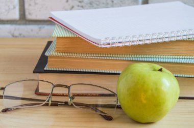 kitap, Apple, defter, gözlük ve kalem ahşap masa üzerinde okuma. Geri okul kavramı.
