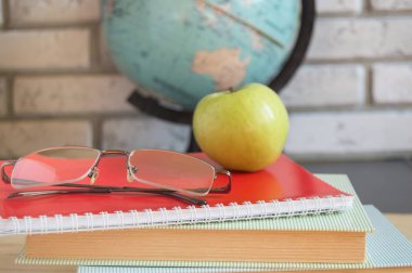 Dünya öğretmenler günü okulda. Kitap, küre, Apple gözlük ile natürmort. seçici odak
