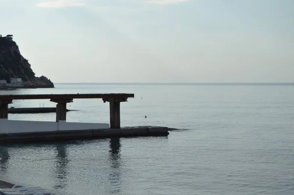 Nascer do sol no mar, cais na costa no início da manhã, calma, relaxar — Fotografia de Stock