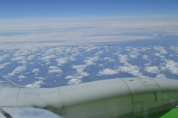 View from the window of the aircraft on the turbine and wing against the blue sky and clouds — Stock Photo, Image