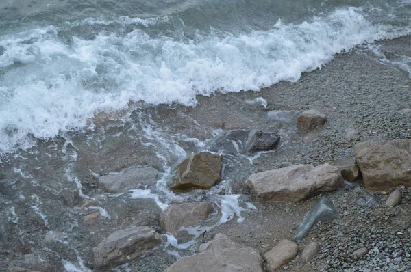 泡と海の波が海岸の岩に打つ — ストック写真