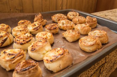 Fırından yeni çıkmış bir fırın tepsisine ev yapımı rulo tarçın yalan