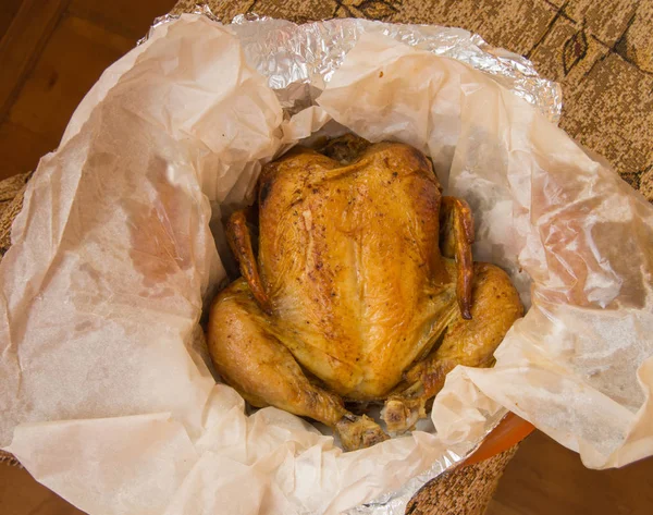 Pollo entero a la parrilla con piel dorada crujiente en pergamino blanco, vista superior, primer plano — Foto de Stock