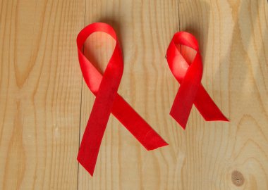 Farkındalık kırmızı kurdele ahşap arka plan üzerinde: AIDS, HIV ile Aralık ayında yaşayan insan sağlığı için genel destek için promosyonlar karşı dünya gün mücadele.