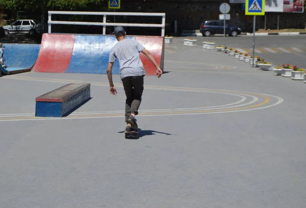 Τύπος έφηβος βόλτες στο πάρκο skateboard και να κάνει κόλπα, η θέα από πίσω — Φωτογραφία Αρχείου