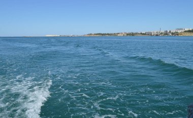 Dalga ve köpük ile arka plan, hızlı hareketli geminin arkasındaki suyun yüzeyinde iz