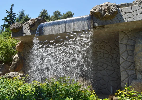 Artificial waterfall with water jets, modern stone structure, beautiful art design in the Park — Stock Photo, Image