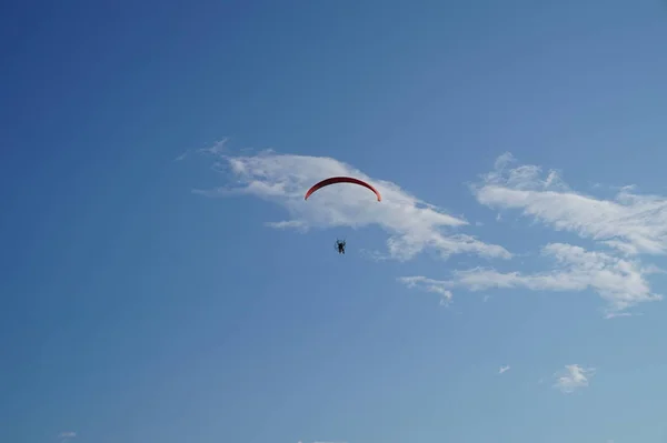 Параплан, летящий в голубом небе, экстремальные виды спорта — стоковое фото