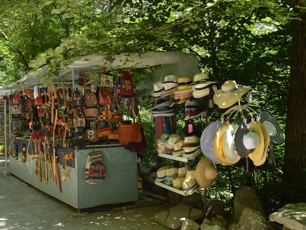 Outdoor souvenir kiosk in the Park with tourist goods hats, bags, backpacks and various accessories