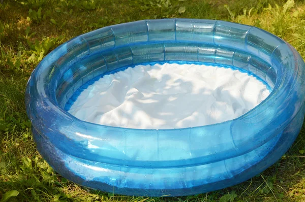 Round inflatable childrens pool stands on the grass in the summer garden — Stock Photo, Image