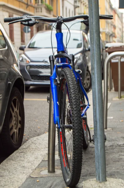 De fiets op straat in de buurt van geparkeerde auto's geparkeerd — Stockfoto