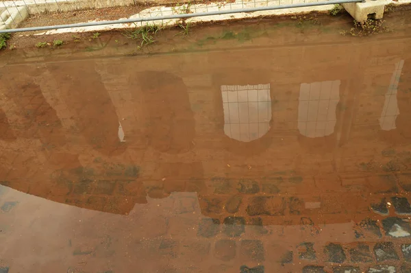 The Colosseum is reflected in a puddle with a brown background, unusual foreshortening sights of Rome Italy — Stock Photo, Image