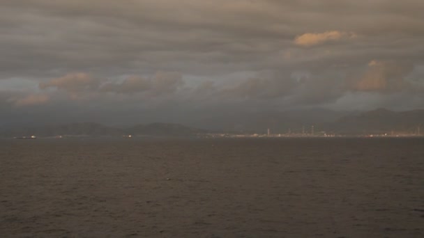 Nézd a hajó a sziklás parton, hajók, felhők, alkonyatkor, a hajó vitorlák múlt Szardínia sziget, Cagliari, 2018. október 9. — Stock videók