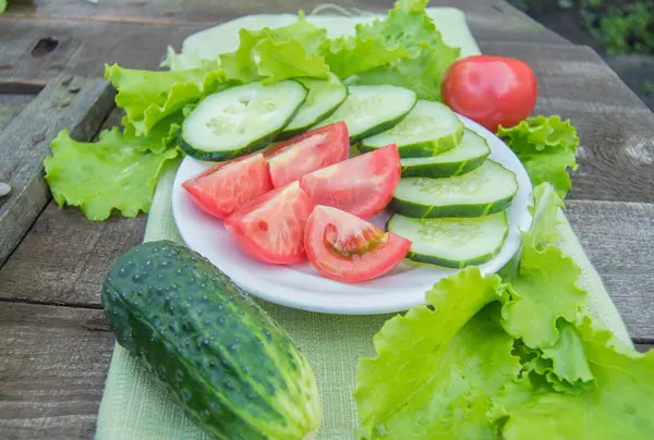 Gurkenscheiben Und Tomaten Liegen Auf Einem Weißen Teller Daneben Salat — Stockfoto