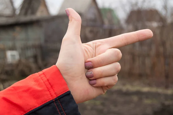 Рука жінки робить знак індексного пальця, що показує напрямок на відкритому повітрі — стокове фото