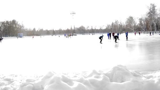 Eine Gruppe von Skatern trainiert auf der offenen Eisbahn im Winterpark am Stadion — Stockvideo