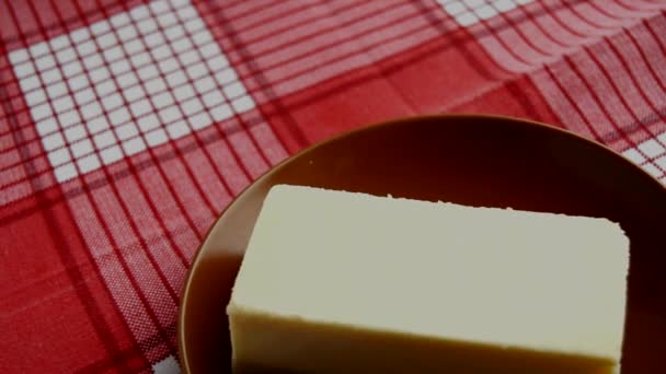 赤い市松模様ナプキンに回転 古典的なニューヨーク チーズケーキの切れ端で茶色のプレート — ストック動画