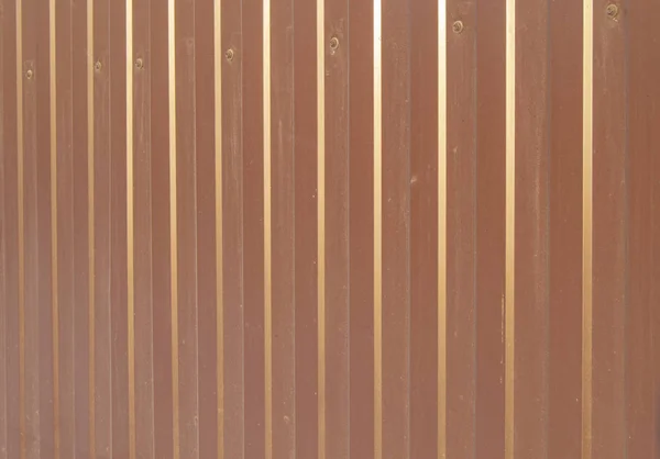 Brown metal siding, modern finishing material for the manufacture of fences and exterior wall cladding.