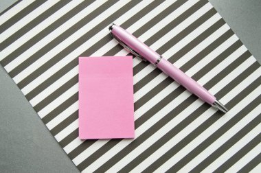 Düz yatış, üst düzey ofis çalışma ortamı. Siyah beyaz çizgiler, çıkartmalar, dolmakalem..