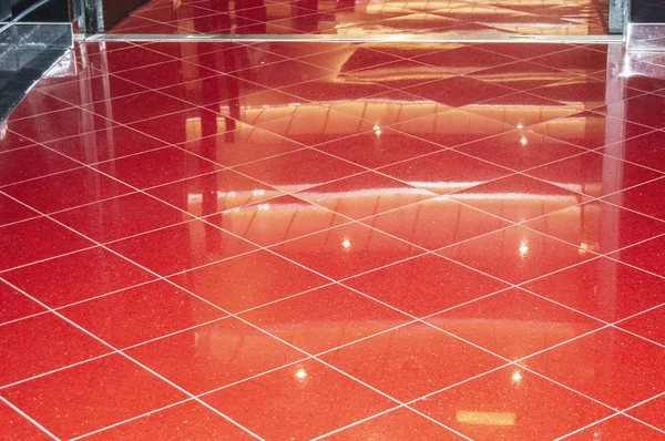 Shiny red Marble floor in luxury office or hotel lobby, floor tiles with reflections for background.