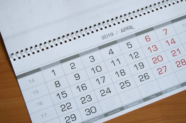 Bakgrund datum på kalendersidan April 2019, på ett träbord — Stockfoto