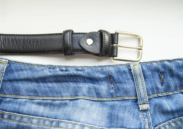 Blue jeans and black leather strap isolated on white background, mens casual clothing — Stock Photo, Image