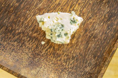 Bir parça peynir ile kalıp bir koyu ahşap plaka, minimalizm, üstten görünüm