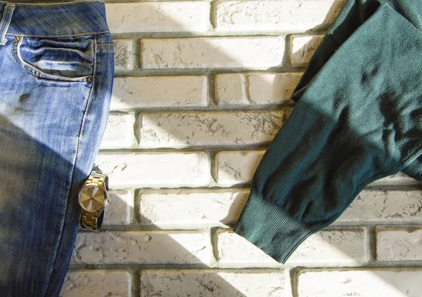 Roupas e acessórios masculinos casuais modernos sobre fundo de tijolo branco, luz solar — Fotografia de Stock