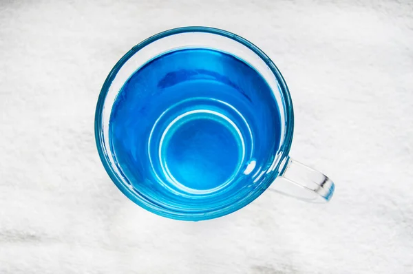 Sauberes Trinkwasser mit Blasen in einem klaren blauen Glas — Stockfoto