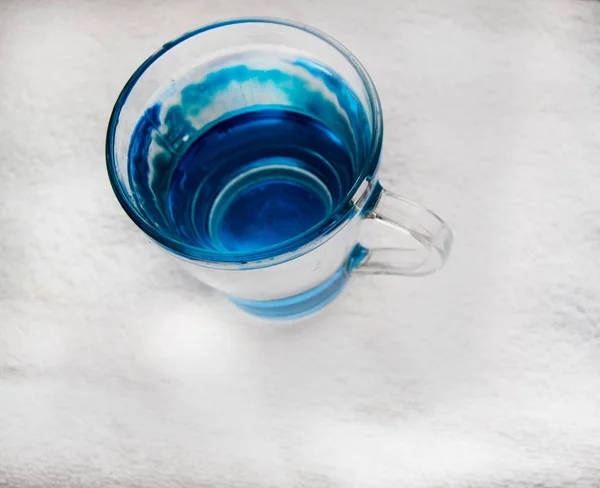 Agua potable limpia con burbujas en un vaso azul claro — Foto de Stock