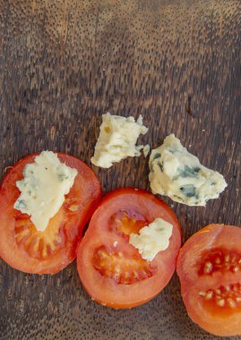 İtalyan mutfak maddeler dilimlenmiş domates ve peynir kalıp ile koyu bir rustik ahşap plaka