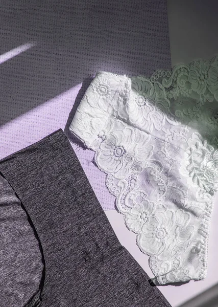 Laço branco calcinha sexy vs preto biquínis têxteis, tiro vertical, vista superior — Fotografia de Stock