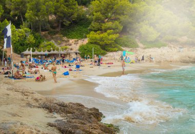 Palma de Mallorca, Balear Adaları, İspanya - 10 Ekim 2018: Palma de Mallorca plajının kumda yatan ve mavi suda yüzen insanlarla görünümü.