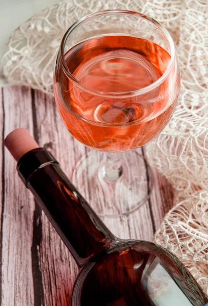 Colpo verticale con effetto colorato - un bicchiere di vino e una bottiglia su un tavolo di legno. Vista dall'alto, piatta — Foto Stock