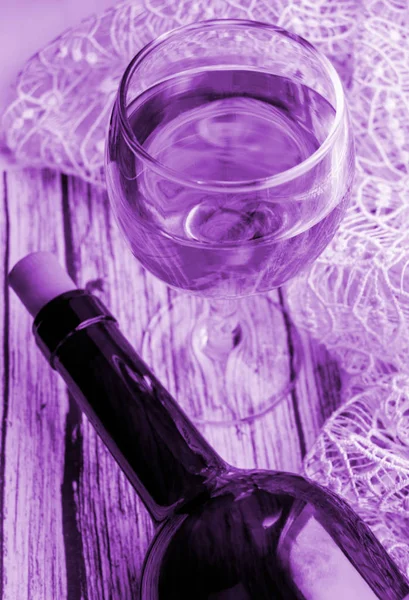垂直拍摄与有色丁香效果 - 一杯葡萄酒和一瓶在木桌上。顶视图，平面 — 图库照片