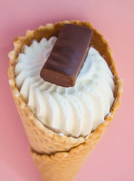 Scoop cono gelato alla vaniglia vista dall'alto con biscotti al cioccolato su sfondo rosa, colpo verticale — Foto Stock