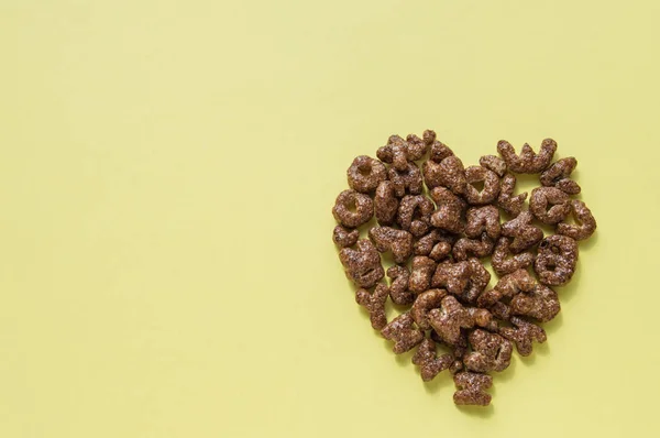 알파벳 문자의 형태로 마른 아침 시리얼의 심장의 기호, 어린이를위한 초콜릿 플레이크 유용한 음식, 상단보기 복사 공간 — 스톡 사진