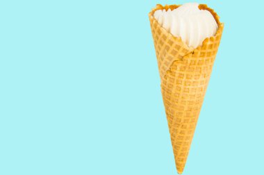 Pastel mavi arka plan üzerinde dondurma koni vanilya. Kopyalama alanı